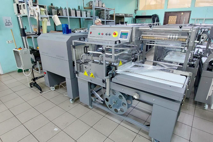 Упаковка лотков. Термоусадочное оборудование “Рамка А” с термотоннелем “УТ 400.001” и аппликатором этикеток “АЭ-140” Упаковка лотков. Термоусадочное оборудование “Рамка А” с термотоннелем “УТ 400.001” и аппликатором этикеток “АЭ-140”