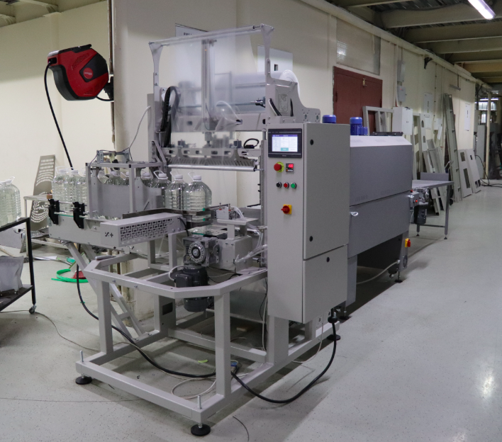 Упаковка бутылок 5 литров. Групповой упаковщик “Верпак А3М” с термотоннелем “УТ-650” Упаковка бутылок 5 литров. Групповой упаковщик “Верпак А3М” с термотоннелем “УТ-650”